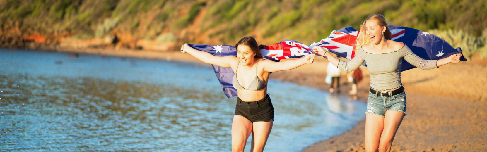 Australien Schüleraustausch Mädchen am Strand mit Flagge